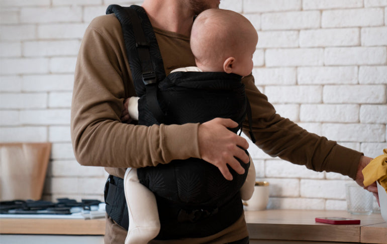 A father holding their baby with the best baby carrier